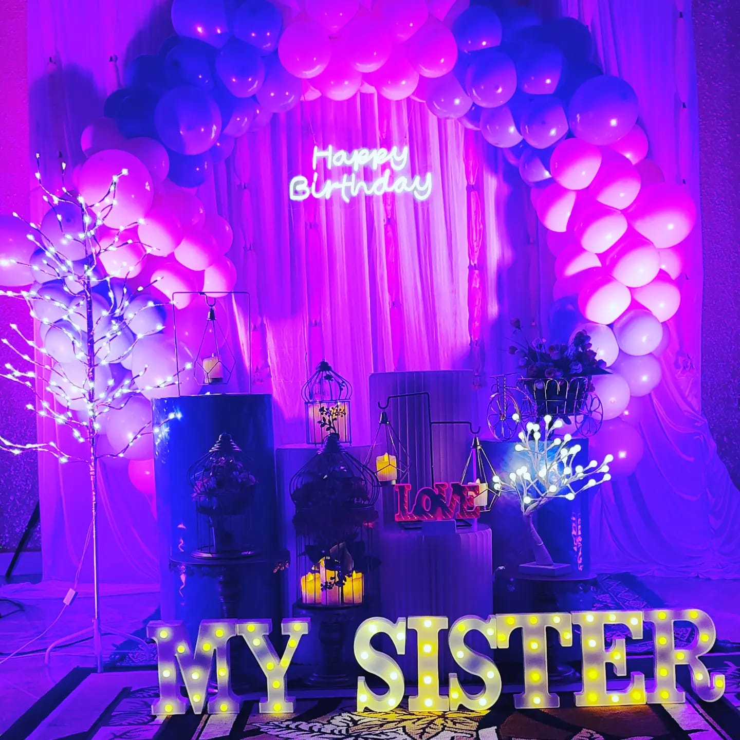Neon Birthday Glow — Violet drapes, neon signage and layered balloons for a milestone birthday.