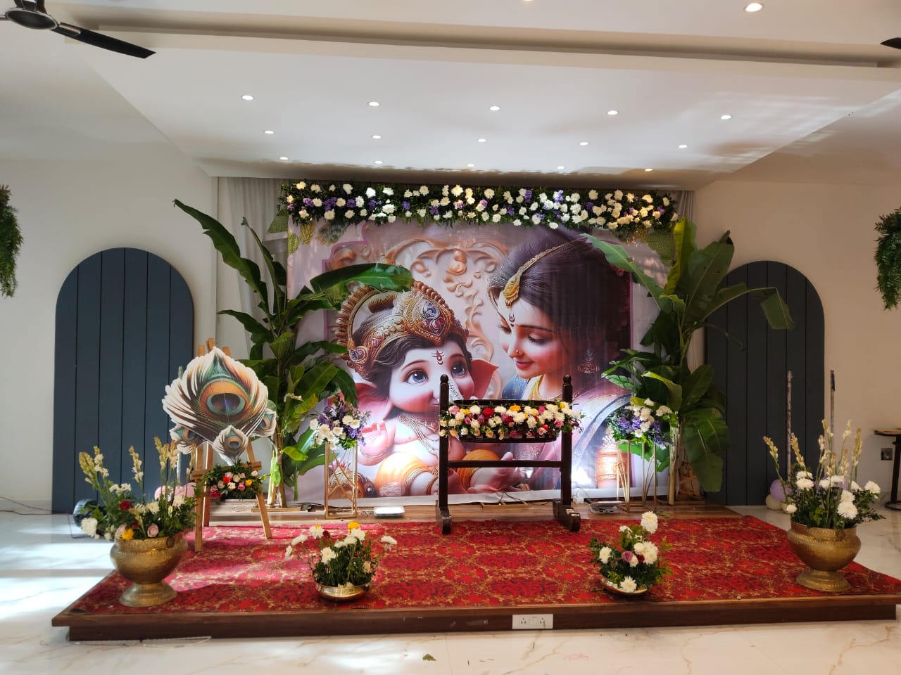 Krishna Cradle Ceremony — A serene Krishna-themed cradle setup with brass urlis and fresh greens.