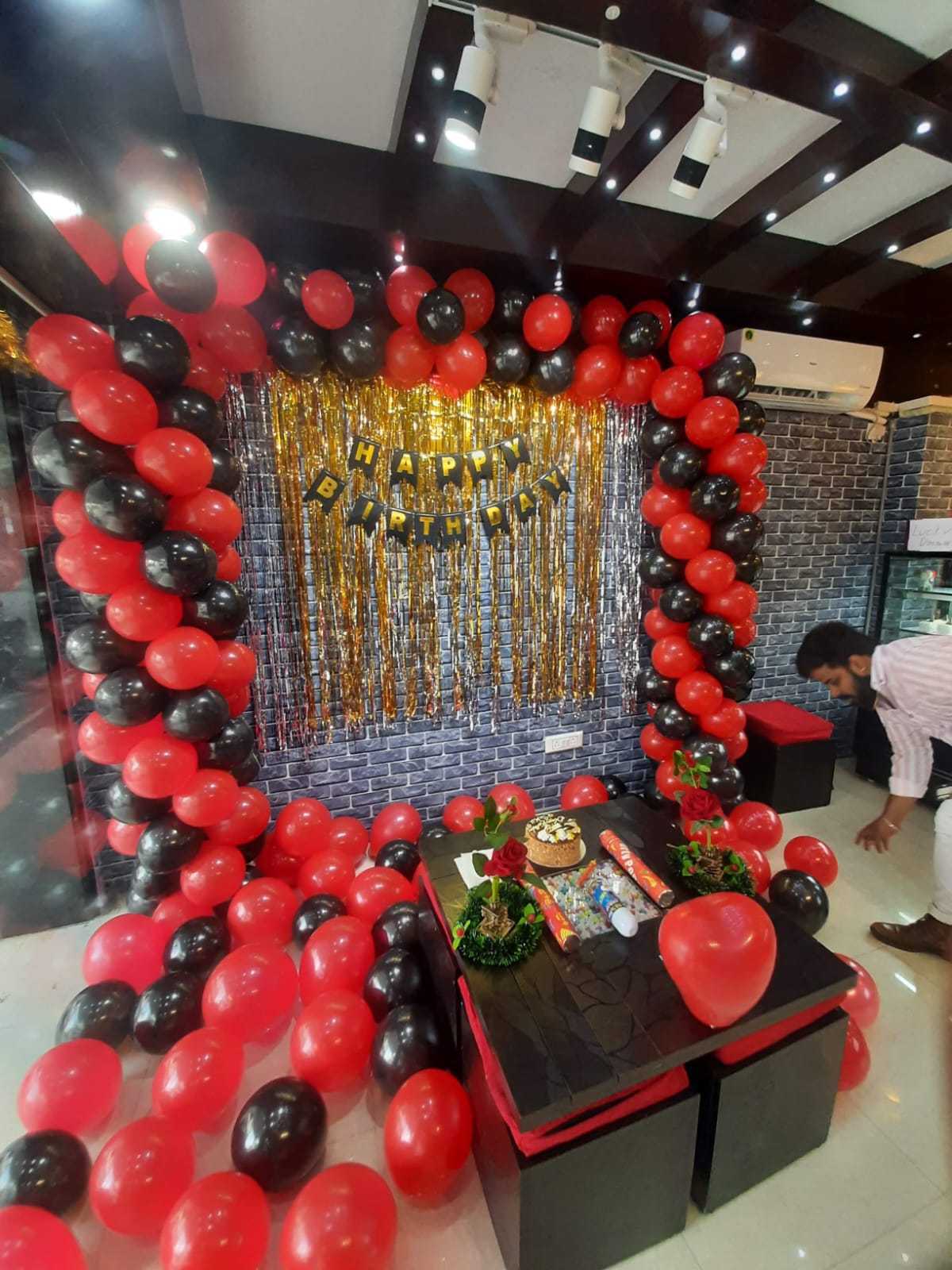 Scarlet & Noir — A dramatic red-and-black balloon arch for a birthday celebration.